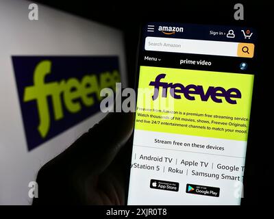 Stuttgart, Deutschland, 11.11.2023: Person, die ein Smartphone hält, mit Webseite des US-Video-on-Demand-Streaming-Dienstes Amazon Freevee vor dem Logo. Fokus Stockfoto