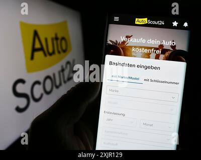 Stuttgart, 14.11.2023: Handybesitzer mit Webseite des deutschen Auto-Online-Marktplatzes AutoScout24 GmbH mit Logo. Konzentrieren Sie sich auf Stockfoto