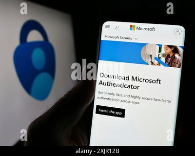 Stuttgart, 14.11.2023: Person, die ein Mobiltelefon hält und die Webseite der Authentifizierungs-App Microsoft Authenticator vor dem Firmenlogo zeigt. Fokus Stockfoto