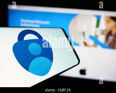 Stuttgart, 14.11.2023: Smartphone mit Logo der Authentifizierungs-App Microsoft Authenticator vor der Business-Website. Fokus links von Stockfoto