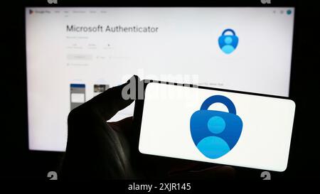 Stuttgart, Deutschland, 14.11.2023: Person, die ein Smartphone mit dem Logo der Authentifizierungs-App Microsoft Authenticator vor der Website hält. Konzentrieren Sie sich auf das Telefon Stockfoto