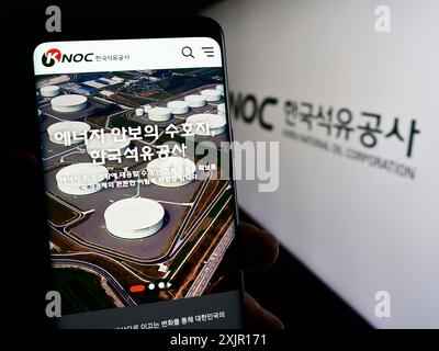 Stuttgart, Deutschland, 16. 11. 2023: Person, die ein Smartphone mit Webseite des Erdölunternehmens Korea National Oil Corporation (KNOC) mit Logo hält. Konzentrieren Sie sich auf Stockfoto