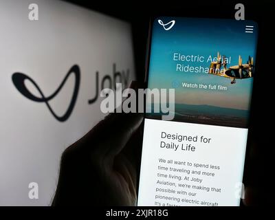 Stuttgart, Deutschland, 16. 11. 2023: Person, die ein Smartphone hält, mit Webseite des US-amerikanischen Flugzeugunternehmens eVTOL Joby Aviation vor dem Geschäftslogo. Konzentrieren Sie sich auf Stockfoto