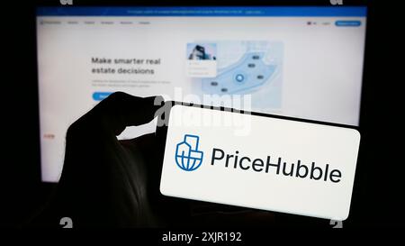 Stuttgart, 15.11.2023: Person mit Mobiltelefon mit Logo des Schweizer Immobilienanalyseunternehmens PriceHubble AG vor Business Web Stockfoto