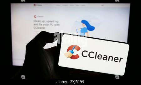 Stuttgart, Deutschland, 15.11.2023: Person, die ein Mobiltelefon mit Logo der Computersystem-Clearing-Software CCleaner vor der Business-Webseite hält. Stockfoto