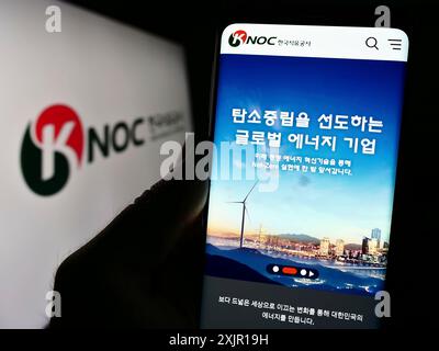Stuttgart, Deutschland, 16. 11. 2023: Person mit Mobiltelefon mit Website des Erdölunternehmens Korea National Oil Corporation (KNOC) mit Logo. Konzentrieren Sie sich auf Stockfoto