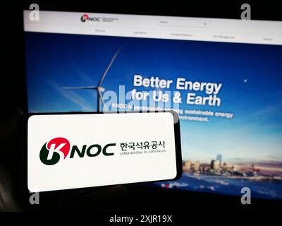 Stuttgart, Deutschland, 16. 11. 2023: Person mit Smartphone mit Logo des Erdölunternehmens Korea National Oil Corporation (KNOC) vor der Website. Stockfoto