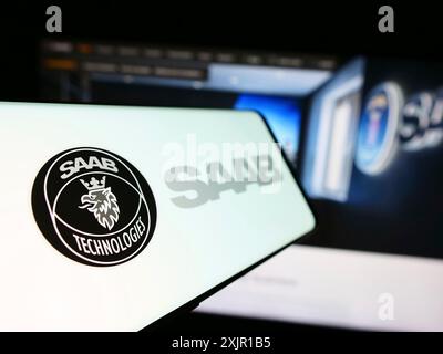 Stuttgart, 16.11.2023: Handy mit Logo des schwedischen Luft- und Raumfahrtunternehmens Saab ab vor der Business-Website. Fokus links von Stockfoto