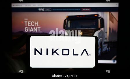 Stuttgart, 17. 11. 2023: Person mit Smartphone mit Logo des US-amerikanischen Elektrofahrzeugunternehmens Nikola Corporation vor der Website. Konzentrieren Sie sich auf Stockfoto