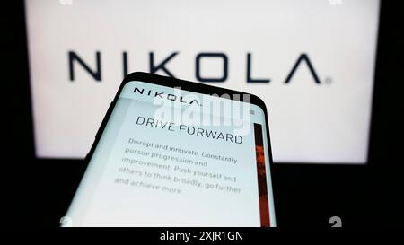 Stuttgart, 17.11.2023: Smartphone mit Website des US-amerikanischen Elektrofahrzeugunternehmens Nikola Corporation vor dem Firmenlogo. Konzentrieren Sie sich auf Stockfoto