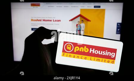 Stuttgart, 24.11.2023: Person, die ein Smartphone mit dem Logo des indischen Finanzunternehmens PNB Housing Finance Limited vor der Website hält. Stockfoto