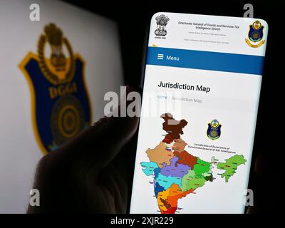 Stuttgart, 28.11.2023: Person, die ein Mobiltelefon hält, mit Website der indischen Generaldirektion GST Intelligence (DGGI) vor dem Logo. Stockfoto