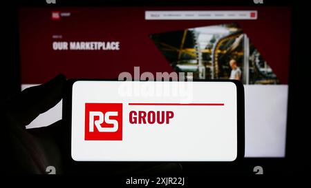 Stuttgart, 24.11.2023: Person, die ein Smartphone mit dem Logo des britischen Stromverteilers RS Group plc vor der Website hält. Stockfoto