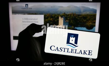 Stuttgart, 29.11.2023: Person mit Mobiltelefon mit Logo der amerikanischen Investmentgesellschaft Castlelake LP vor der Website. Stockfoto