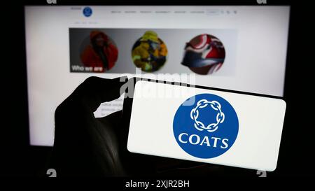 Stuttgart, Deutschland, 12.06.2023: Person mit Smartphone mit Logo des britischen Textilmaterialunternehmens Coats Group plc vor der Website. Konzentrieren Sie sich auf Stockfoto