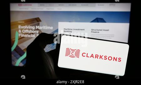 Stuttgart, Deutschland, 12.06.2023: Person mit Smartphone mit Logo des britischen Logistikunternehmens Clarkson plc (Clarksons) vor der Website. Fokus Stockfoto