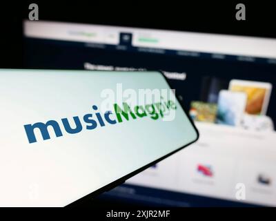 Stuttgart, 12.07.2023: Handy mit Logo des britischen E-Commerce-Unternehmens MusicMagpie vor der Business-Website. Fokussiere dich links vom Telefon Stockfoto