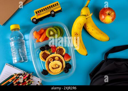 Schulbrotdose mit Pfannkuchen, Gemüse und Obst. Stockfoto