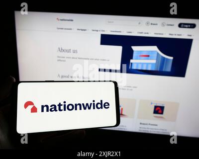 Stuttgart, 14.12.2023: Person, die ein Smartphone mit dem Logo des britischen Finanzinstituts Nationwide Building Society vor der Website hält. Stockfoto