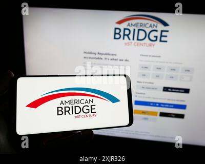 Stuttgart, 14.12.2023: Person, die ein Smartphone mit dem Logo der liberalen Super PAC American Bridge 21st Century vor der Website hält. Konzentrieren Sie sich auf Stockfoto