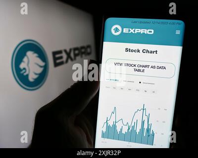 Stuttgart, 14.12.2023: Person, die ein Mobiltelefon hält und die Webseite des amerikanischen Öl- und Gasunternehmens Expro Group vor dem Firmenlogo zeigt. Konzentrieren Sie sich auf Stockfoto
