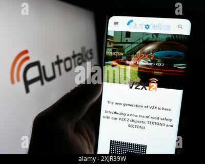 Stuttgart, Deutschland, 18.12.2023: Person, die ein Smartphone hält, mit Webseite des israelischen Automobilhersteller Autotalks Ltd. Vor dem Logo. Stockfoto