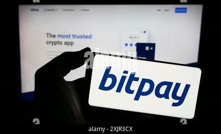 Stuttgart, Deutschland, 18.12.2023: Person, die ein Smartphone mit dem Logo des US-amerikanischen Kryptowährungs-Zahlungsunternehmens BitPay Inc. Vor der Website hält. Konzentrieren Sie sich auf Stockfoto