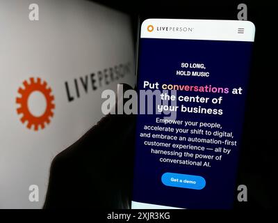 Stuttgart, 20.12.2023: Person, die ein Smartphone hält, mit der Webseite des Konversationsunternehmens LivePerson Inc. Vor dem Logo. Konzentrieren Sie sich auf Stockfoto
