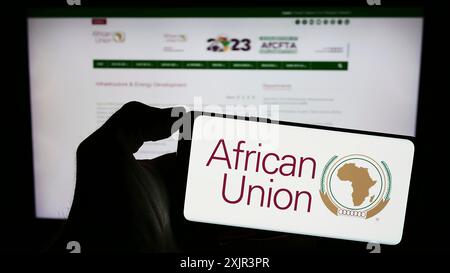 Stuttgart, 27.12.2023: Person mit Handy mit Logo der kontinentalen Organisation Afrikanische Union (AU) vor der Webseite. Konzentrieren Sie sich auf das Telefon Stockfoto