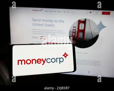 Stuttgart, 23.12.2023: Person, die ein Smartphone mit dem Logo des britischen Zahlungsunternehmens TTT Moneycorp Limited vor der Website hält. Konzentrieren Sie sich auf Stockfoto