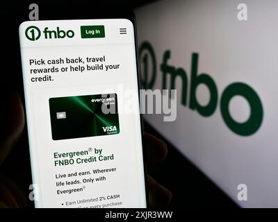 Stuttgart, Deutschland, 28.12.2023: Person, die ein Smartphone mit Webseite des US-amerikanischen Finanzunternehmens First National Bank Omaha (FNBO) mit Logo hält. Konzentrieren Sie sich auf Stockfoto