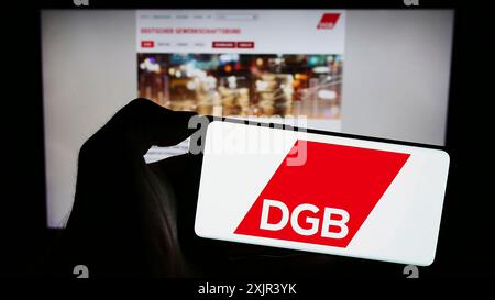 Stuttgart, 29.12.2023: Handybesitzer mit Logo des Deutschen Gewerkschaftsbundes (DGB) vor der Webseite. Stockfoto