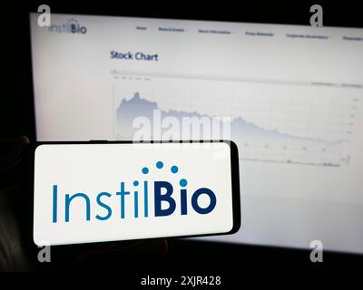 Stuttgart, Deutschland, 12-31-2023: Person, die ein Mobiltelefon mit Logo des amerikanischen Biotechnologie-Unternehmens instil Bio Inc. Vor dem Business Web hält Stockfoto