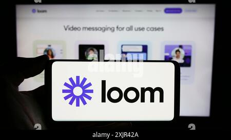 Stuttgart, 29.12.2023: Person, die ein Smartphone mit dem Logo des US-amerikanischen Unternehmens Loom Inc. Vor der Website hält. Fokus Stockfoto