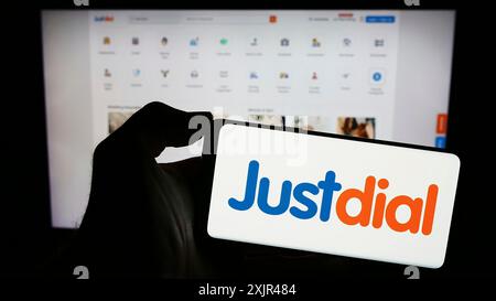 Stuttgart, Deutschland, 12.31.2023: Person mit Smartphone mit Logo des indischen Technologieunternehmens Just Dial Limited (Justdial) vor der Website. Stockfoto