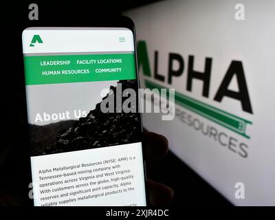 Stuttgart, Deutschland, 02-08-2024: Person, die ein Mobiltelefon hält, mit Webseite des US-Bergbauunternehmens Alpha Metallurgical Resources Inc. Vor dem Logo. Fokus Stockfoto