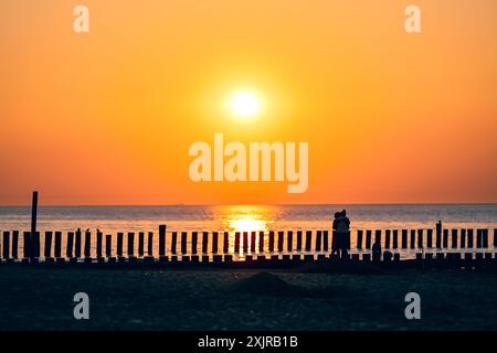 Reise - Wangerooge 2024 Uhr 19.07.2024 Strand von Wangerooge beim Sonnenuntergang. Ein verliebtes Paar steht sich beim Sonnenuntergang gegenüber. Foto: Osnapix Reisen - Wangerooge 2024 *** Reise Wangerooge 2024 am 19 07 2024 Strand von Wangerooge bei Sonnenuntergang Ein verliebtes Paar, das sich bei Sonnenuntergang gegenübersieht Foto osnapix Travel Wangerooge 2024 MT Stockfoto