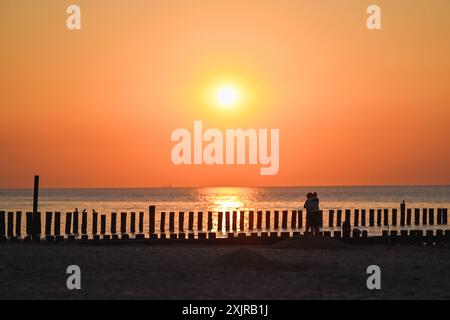 Reise - Wangerooge 2024 Uhr 19.07.2024 Strand von Wangerooge beim Sonnenuntergang. Ein verliebtes Paar steht sich beim Sonnenuntergang gegenüber. Foto: Osnapix Reisen - Wangerooge 2024 *** Reise Wangerooge 2024 am 19 07 2024 Strand von Wangerooge bei Sonnenuntergang Ein verliebtes Paar, das sich bei Sonnenuntergang gegenübersieht Foto osnapix Travel Wangerooge 2024 MT Stockfoto