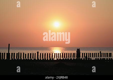 Reise - Wangerooge 2024 Uhr 19.07.2024 Strand von Wangerooge beim Sonnenuntergang. Ein verliebtes Paar steht sich beim Sonnenuntergang gegenüber. Foto: Osnapix Reisen - Wangerooge 2024 *** Reise Wangerooge 2024 am 19 07 2024 Strand von Wangerooge bei Sonnenuntergang Ein verliebtes Paar, das sich bei Sonnenuntergang gegenübersieht Foto osnapix Travel Wangerooge 2024 MT Stockfoto