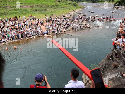 Congjiang, China. Juli 2024. Ein junger Mann der Zhuang-Nationalität nimmt am 19. Juli 2024 am jährlichen „Tauchfest“ im Gangbian-Dorf im Bezirk Congjiang in der südwestchinesischen Provinz Guizhou Teil. (Foto: Costfoto/NurPhoto) Credit: NurPhoto SRL/Alamy Live News Stockfoto