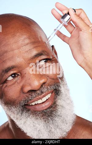 Serum, schwarzer Mann oder Seniorgesicht im Studio für Hautpflege, Hautfeuchtigkeit oder Vitamin-C-Behandlung. Dermatologe Hand, Tropfer oder ältere Person auf Blau Stockfoto