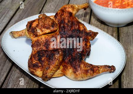 Pollo alla Diavola Spatchcocked Italian gegrilltes warmes Huhn, gewürzt mit Peperoncino Chili und serviert mit Fagiole All Uccelletto Bohnen Stockfoto