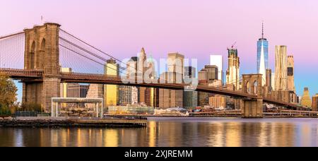 Panorama der Skyline von Manhattan bei Sonnenaufgang vom Brooklyn Bridge Park Stockfoto