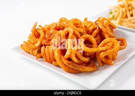 Ein Blick auf einen Teller mit lockigen Pommes. Stockfoto
