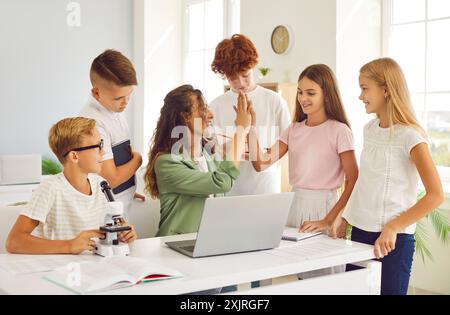 Lehrer, der Eine Schulstunde leitet und High Five mit Schülern im Klassenzimmer gibt Stockfoto