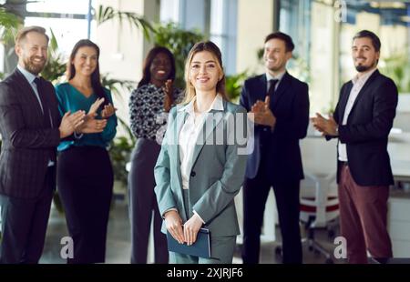 Lächelnde, schöne, professionelle Führungsleiterin, die im Büro in die Kamera blickt Stockfoto