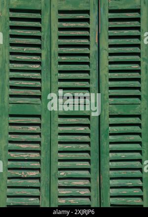 Hölzerne, grüne, alte Fensterläden am Fenster Stockfoto