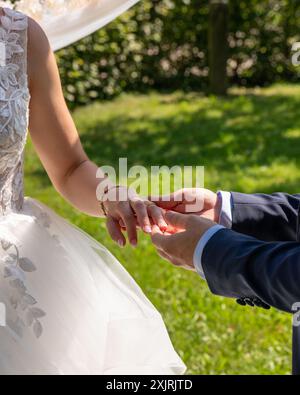 Der Bräutigam legt den Ehering auf die Braut bei der Hochzeitszeremonie. Hand in Hand. Hochzeit, Urlaub, Verlobung. Stockfoto