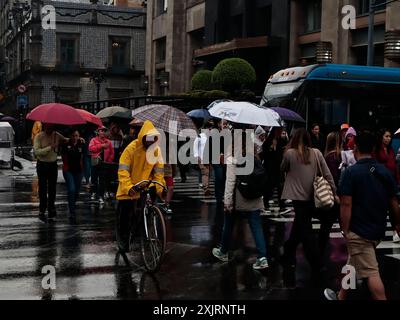 Mexiko-Stadt, Mexiko. Juli 2024. Nach der intensiven Hitze, die an früheren Daten aufgezeichnet wurde, haben die intensiven Regenfälle in verschiedenen Gebieten von CDMX Überschwemmungen verursacht. Dies zwingt Einwohner und Touristen, sich mit Regenschirmen und Plastikregenmänteln zu schützen, um ihre Arbeit oder Spaziergänge am 19. Juli 2024 in Mexiko-Stadt, Mexiko, fortzusetzen. (Foto: Josue Perez/SIPA USA) Credit: SIPA USA/Alamy Live News Stockfoto