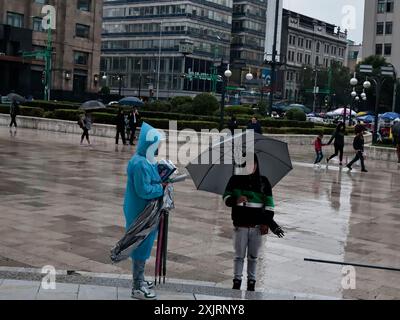 Mexiko-Stadt, Mexiko. Juli 2024. Nach der intensiven Hitze, die an früheren Daten aufgezeichnet wurde, haben die intensiven Regenfälle in verschiedenen Gebieten von CDMX Überschwemmungen verursacht. Dies zwingt Einwohner und Touristen, sich mit Regenschirmen und Plastikregenmänteln zu schützen, um ihre Arbeit oder Spaziergänge am 19. Juli 2024 in Mexiko-Stadt, Mexiko, fortzusetzen. (Foto: Josue Perez/SIPA USA) Credit: SIPA USA/Alamy Live News Stockfoto